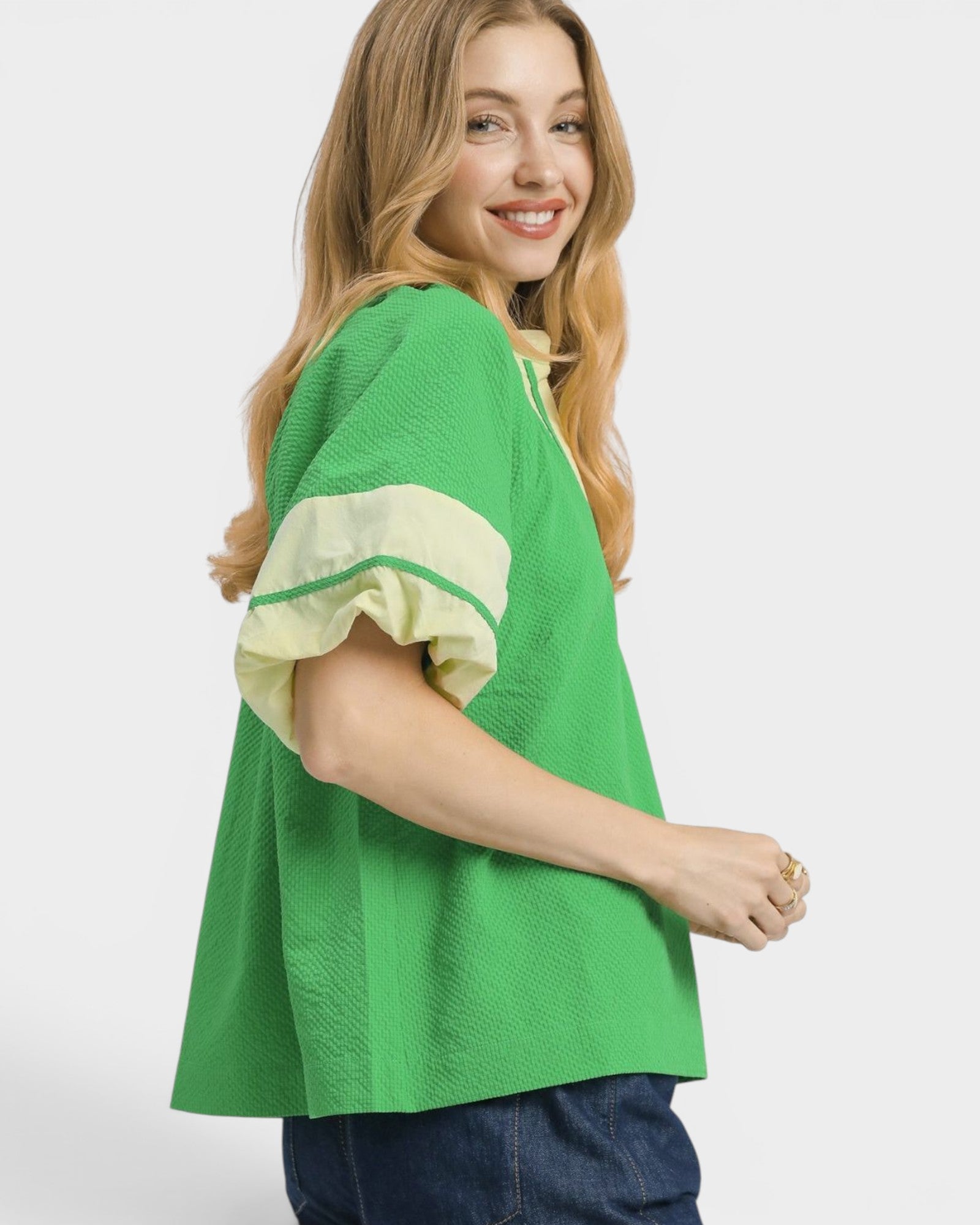 Woman wearing a green and yellow top on a white background