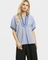 Woman wearing a blue and white striped shirt with black pants on a white background