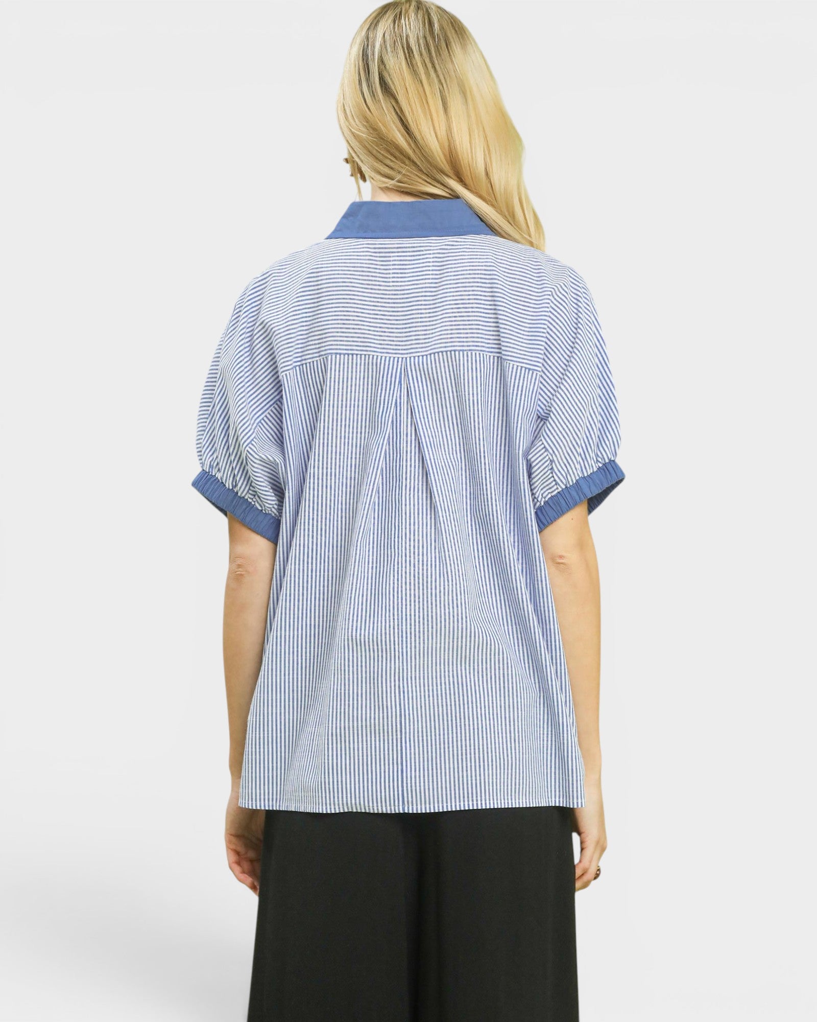 Person wearing a blue and white striped shirt on a white background