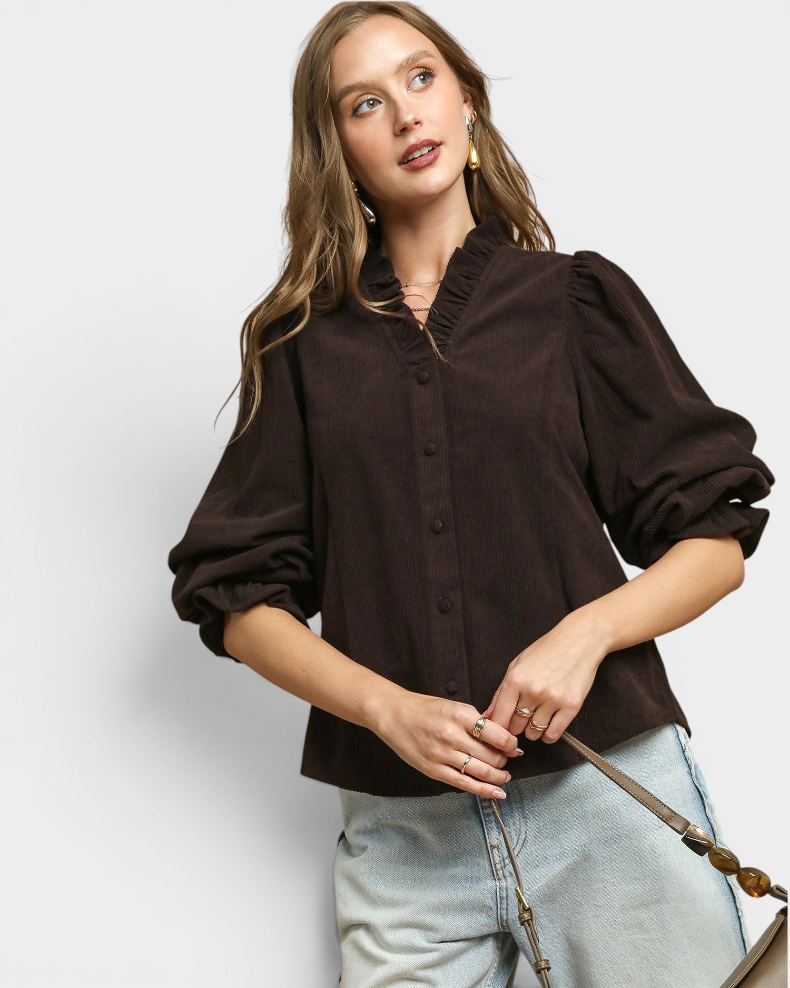 Woman wearing a brown blouse with puffed sleeves on a white background
