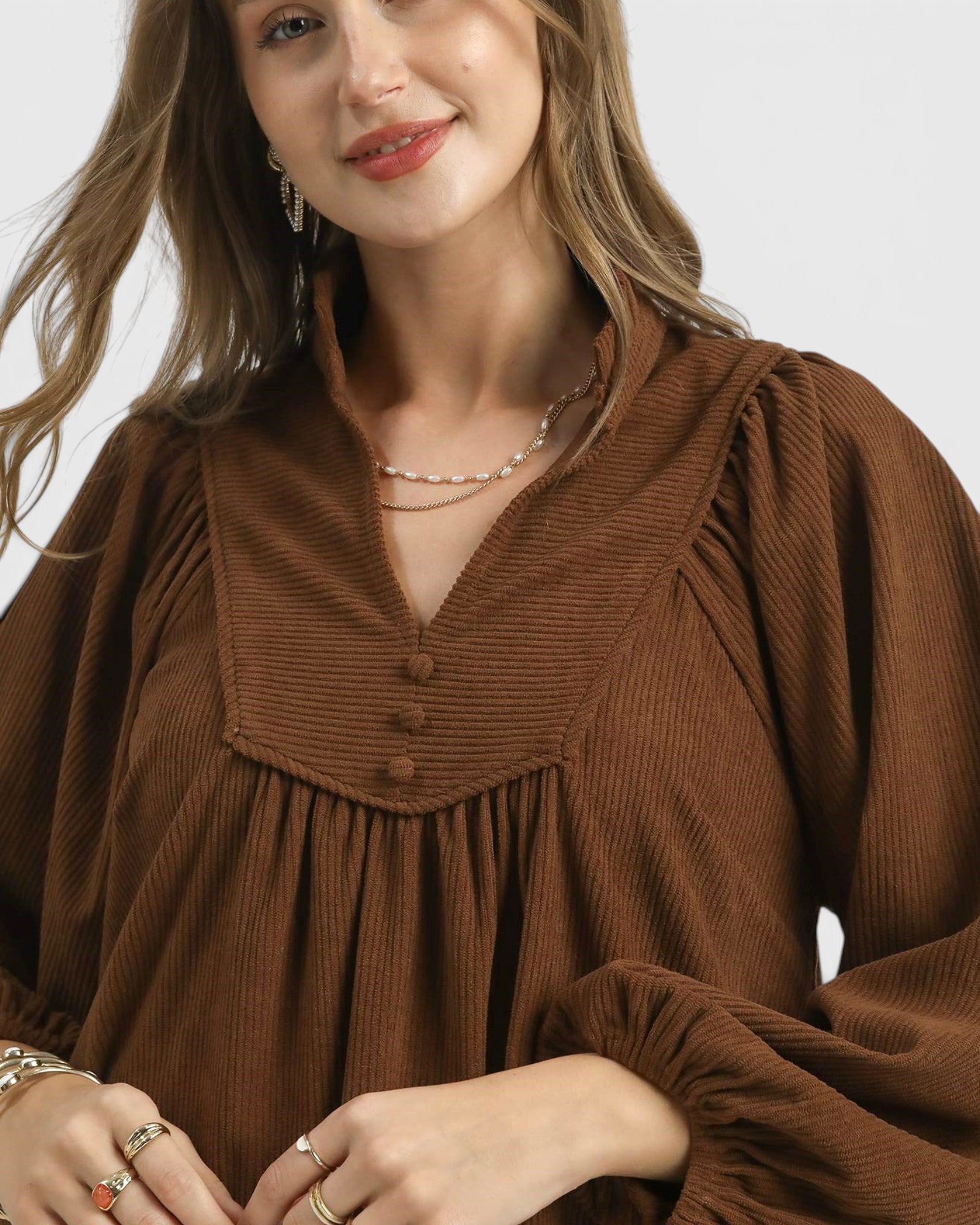 Woman wearing a brown dress with a plain background