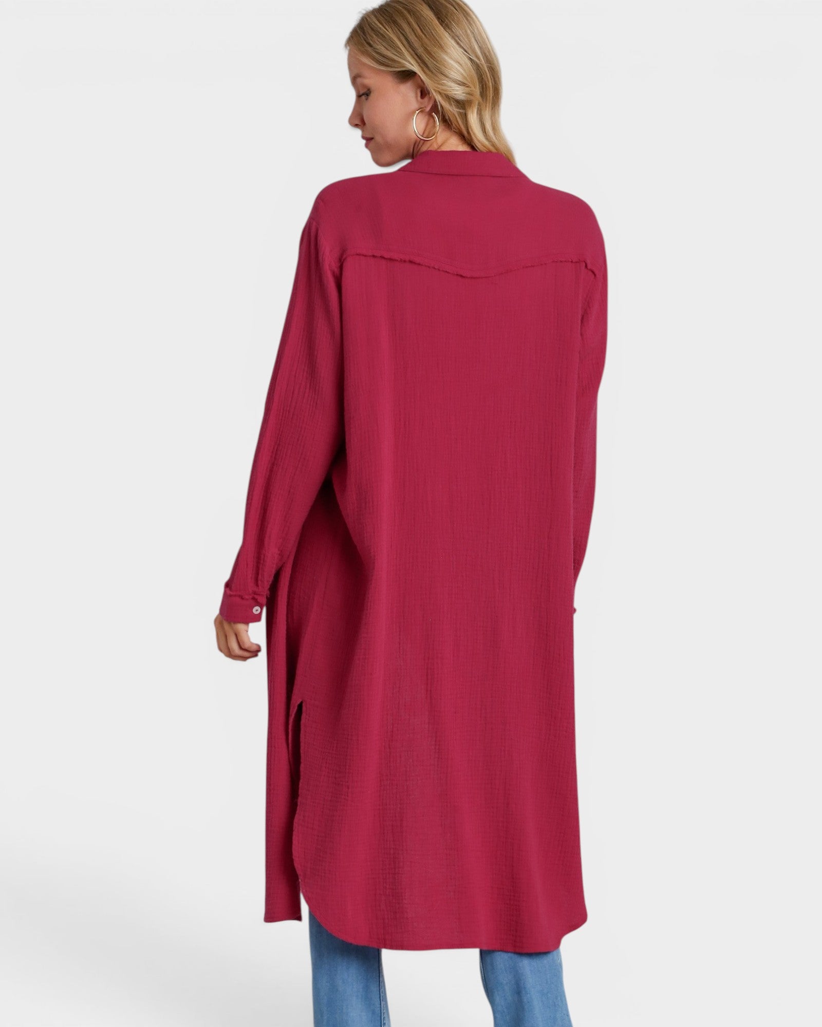 Woman wearing a long burgundy shirt on a white background