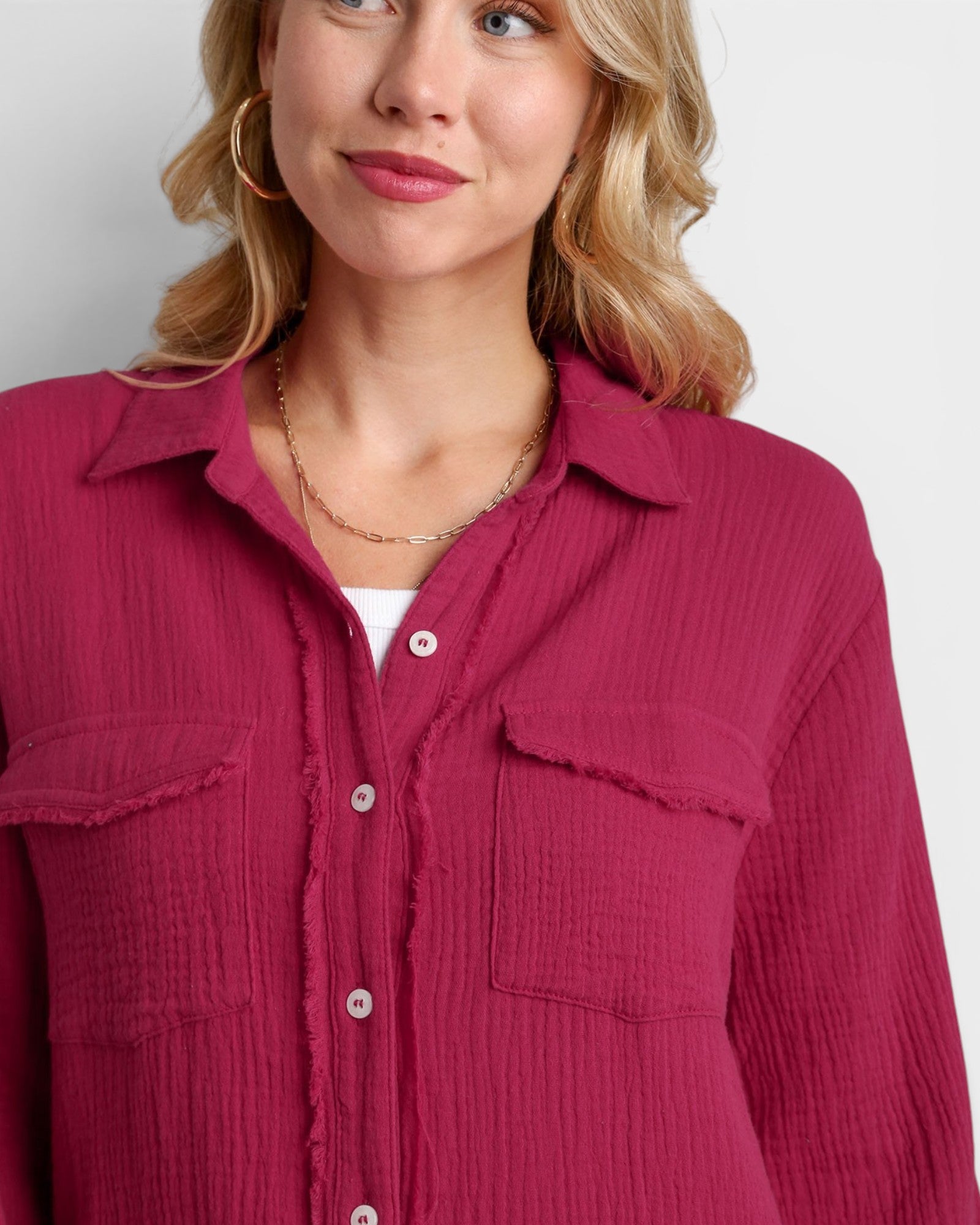 Woman wearing a pink textured shirt against a white background
