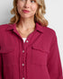 Woman wearing a pink textured shirt against a white background