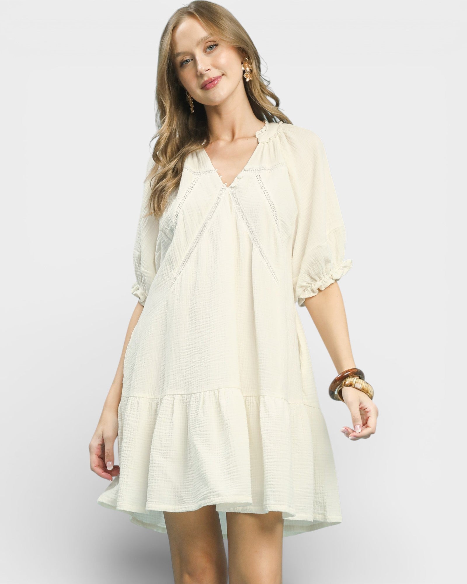 Woman wearing a light-colored dress on a plain background