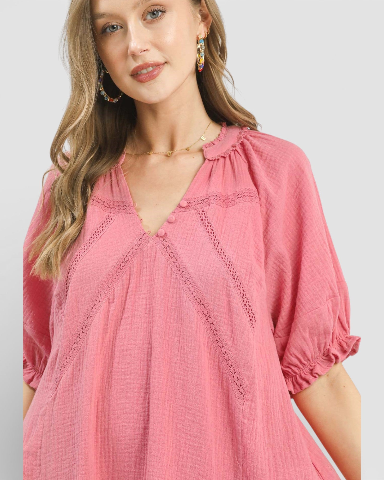 Woman wearing a pink blouse with a plain background