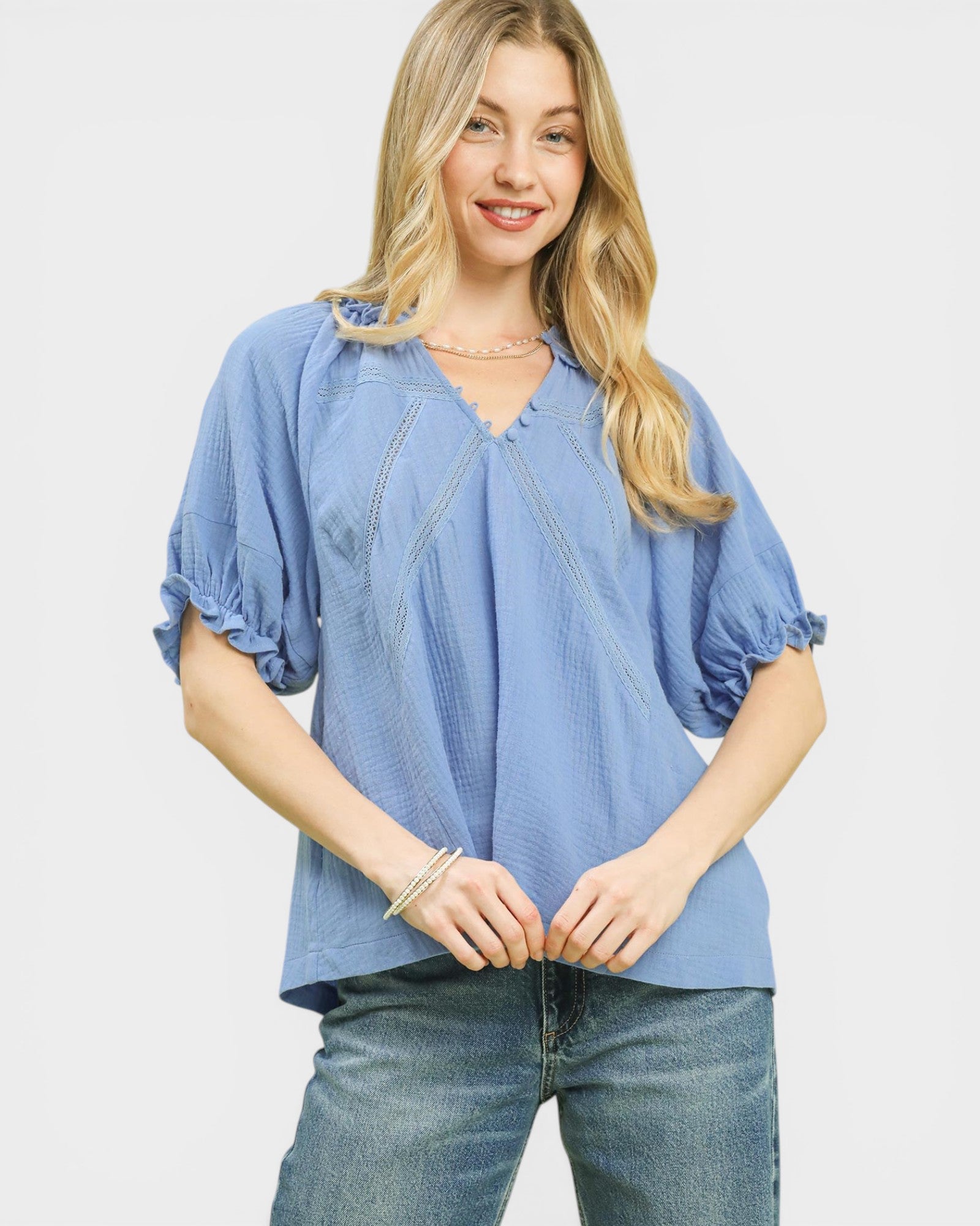 Woman wearing a blue blouse and jeans on a white background