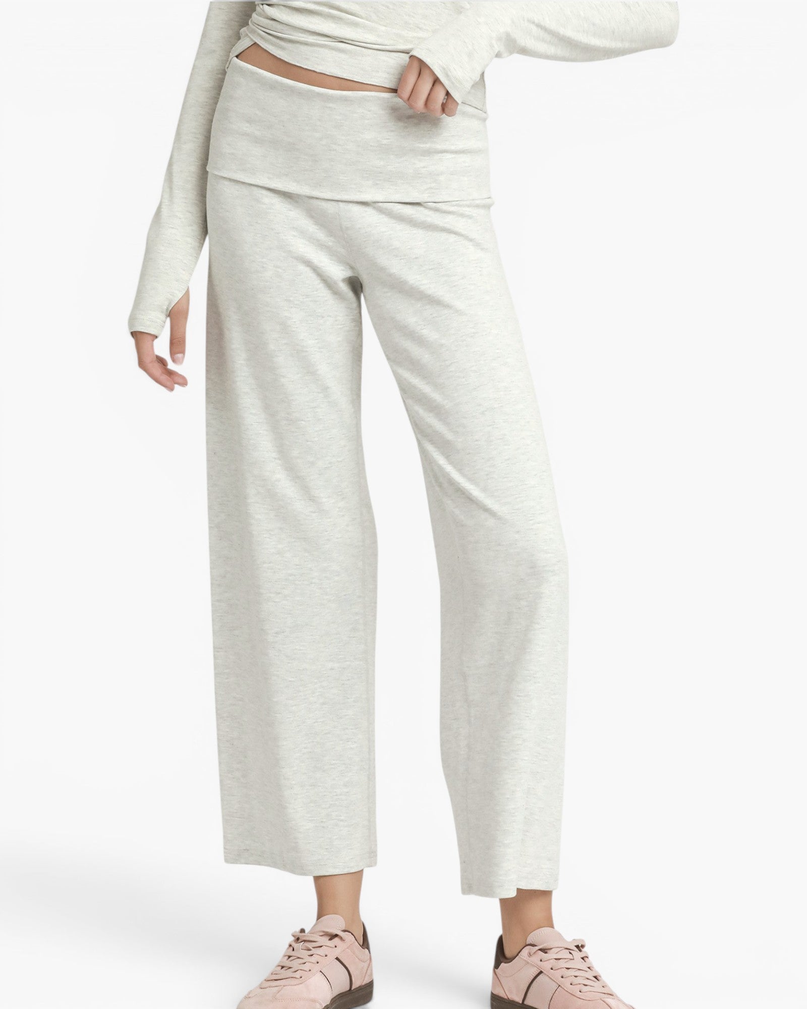 A model wearing light heather gray wide-leg cropped pants with a matching long-sleeve top and pink sneakers, shown against a plain light gray studio background.