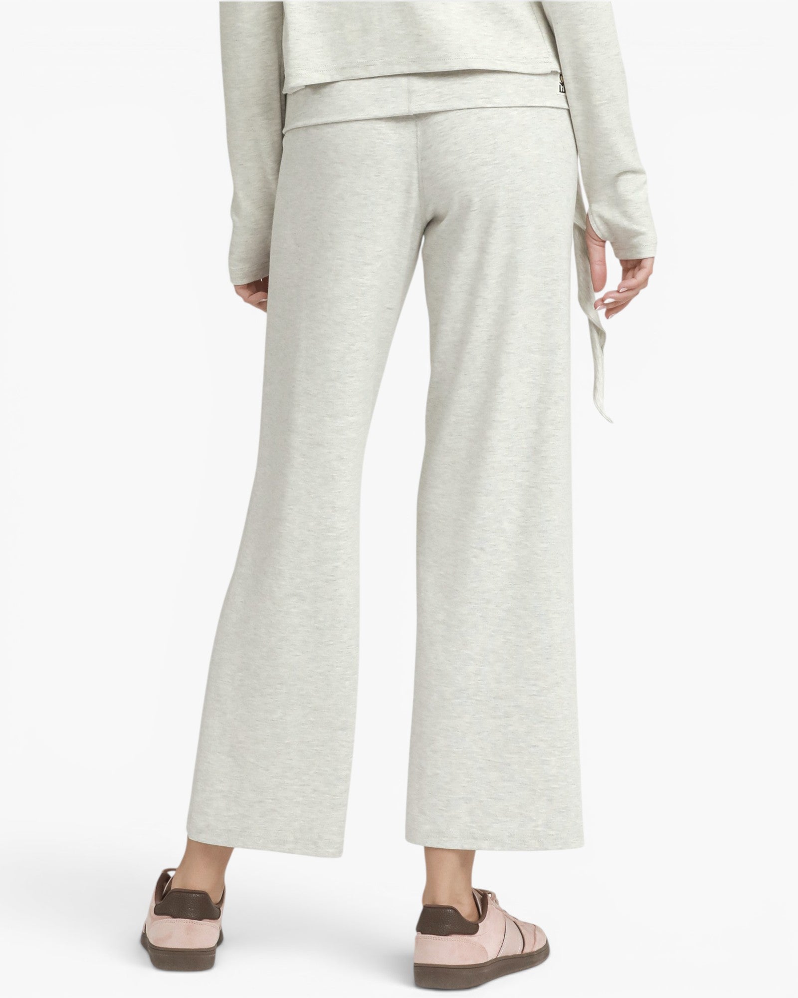 A person shown from the back wearing light heather gray wide-leg cropped pants with a matching top and pink-brown slip-on shoes, against a plain light gray studio background.