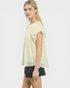 Woman wearing a light-colored blouse and black shorts on a white background