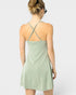 Woman wearing a light green dress with thin straps on a white background