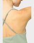 Green dress with criss-cross straps on a plain background