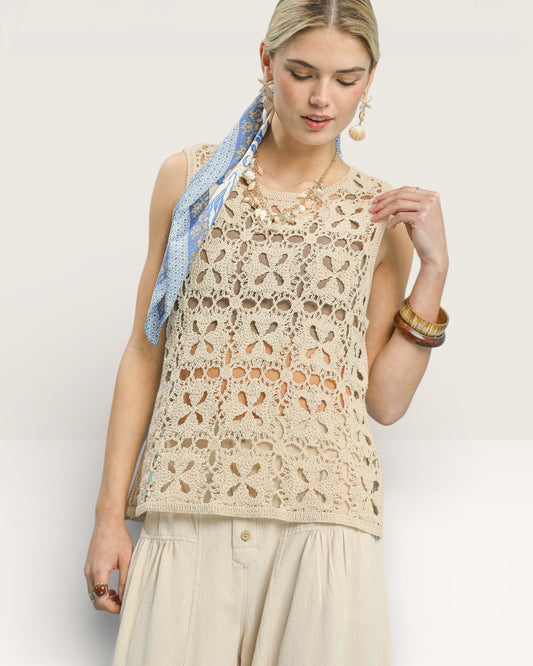 Woman wearing a beige lace top with a blue scarf on a white background