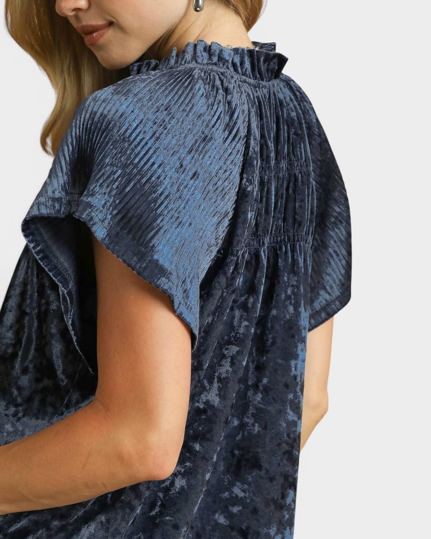 Navy blue textured blouse worn by a person on a white background