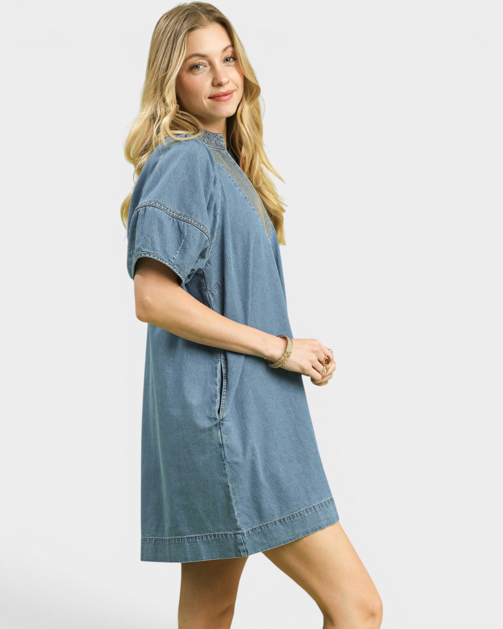 Woman wearing a denim dress on a white background