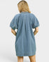 Blue denim dress worn by a person on a white background