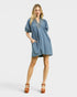 Woman wearing a blue denim dress on a white background