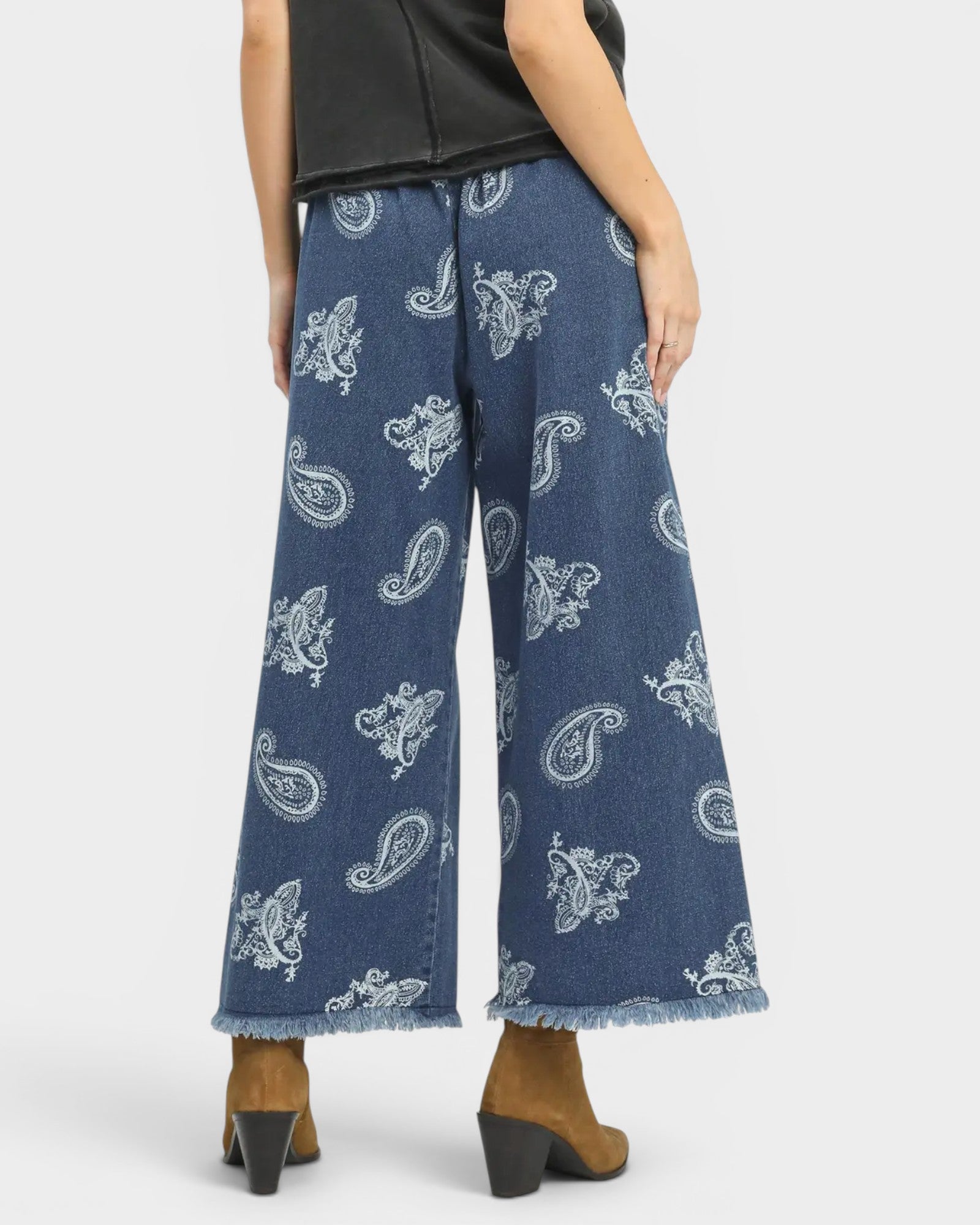 Blue paisley-patterned jeans worn by a person on a white background