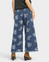 Blue paisley-patterned jeans worn by a person on a white background