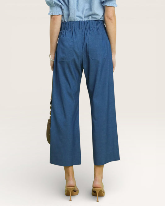 Person wearing blue wide-leg pants on a plain background