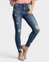Person wearing distressed blue jeans on a white background