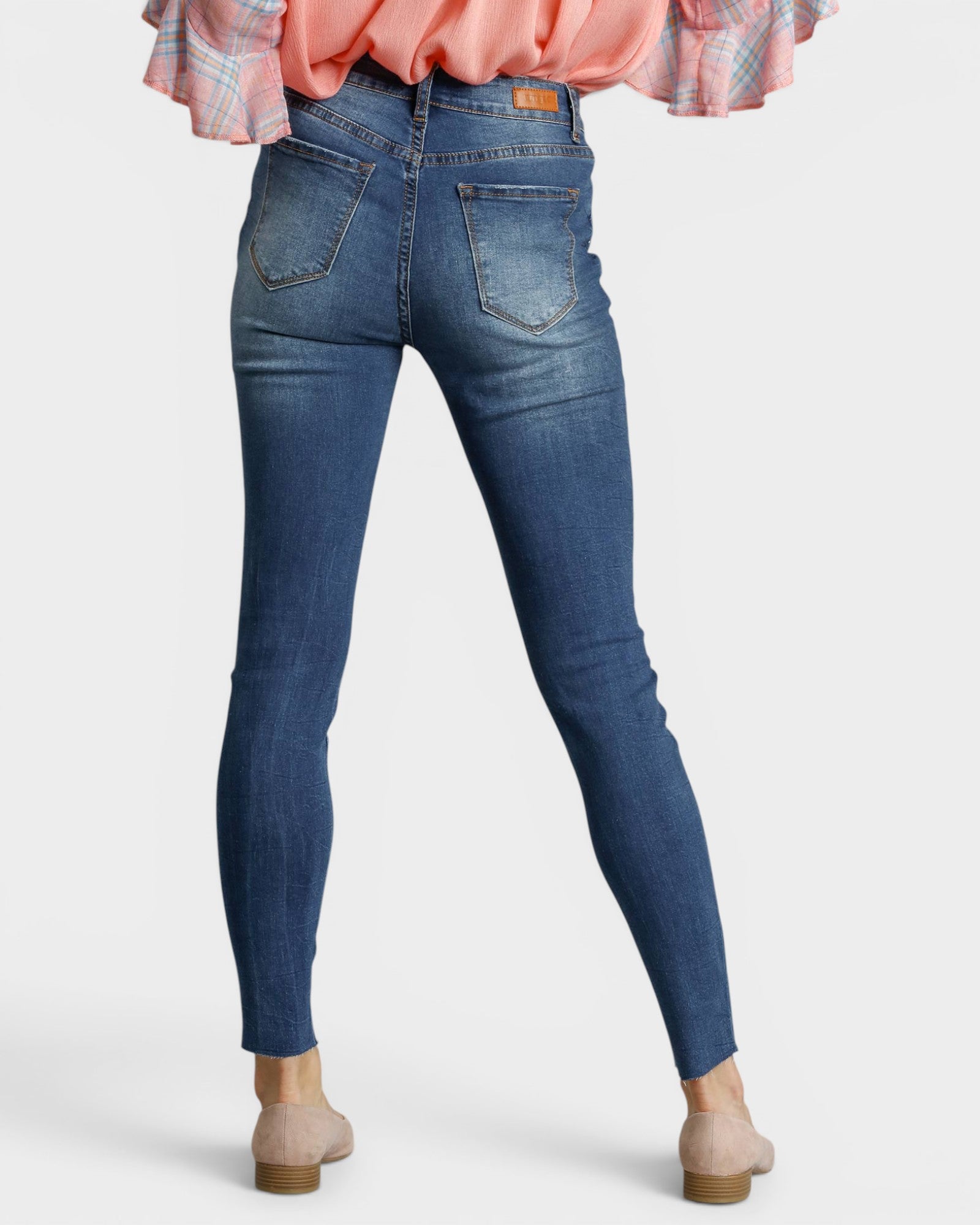 Blue jeans worn by a person on a white background