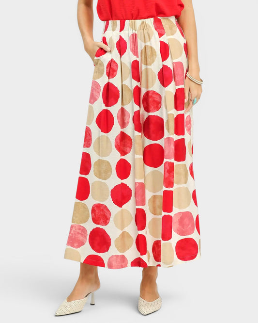Person wearing a red and beige patterned skirt on a white background