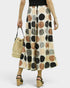 Person wearing patterned pants holding a straw bag on a white background
