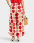 Person wearing a red and beige polka dot skirt on a white background