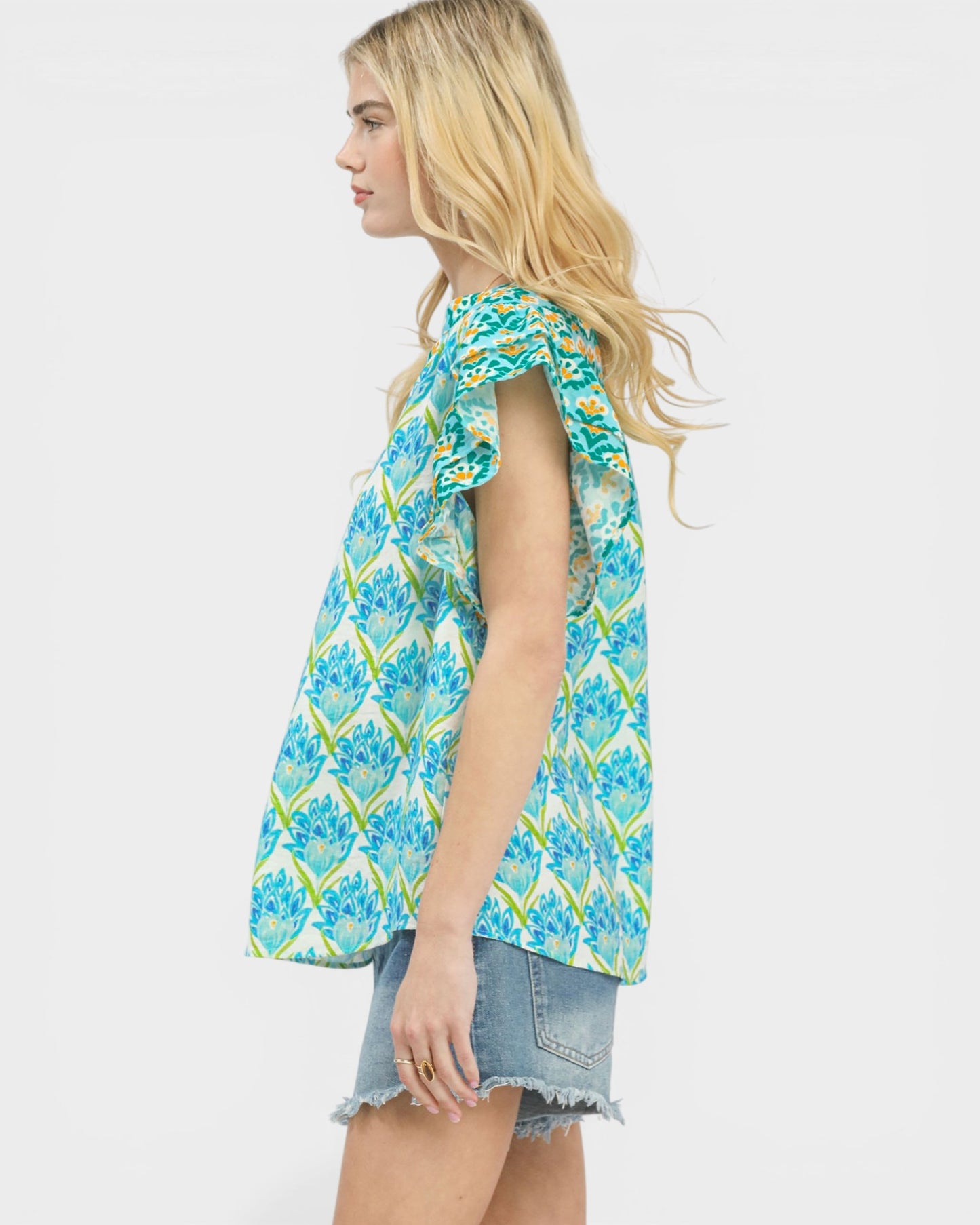 Woman wearing a blue floral sleeveless top on a white background