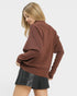 Woman wearing a brown sweater and black leather skirt on a white background