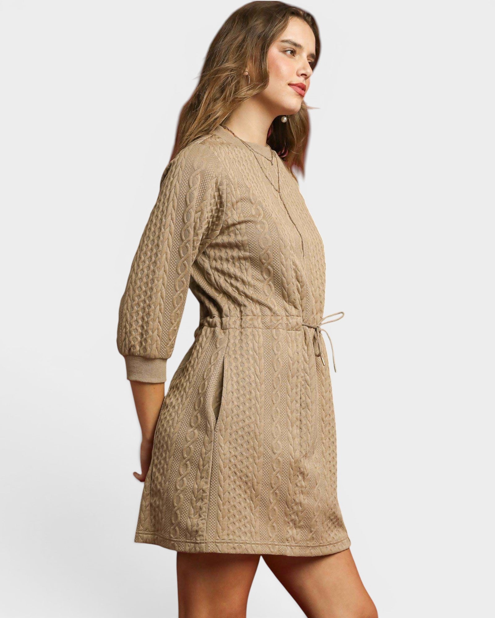 Woman wearing a beige textured dress on a white background