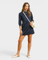 Woman wearing a navy blue dress with a white background