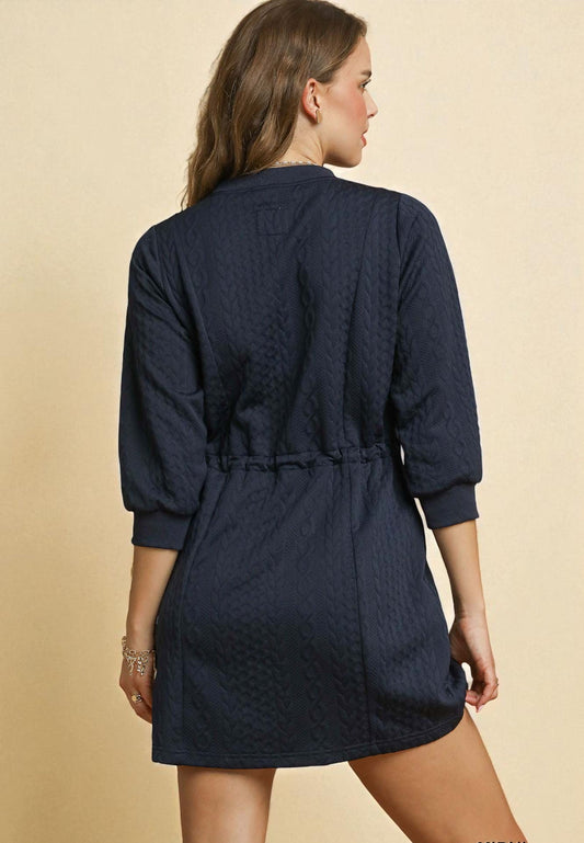 Navy blue dress worn by a person on a beige background