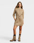 Woman wearing a beige dress with matching boots on a white background