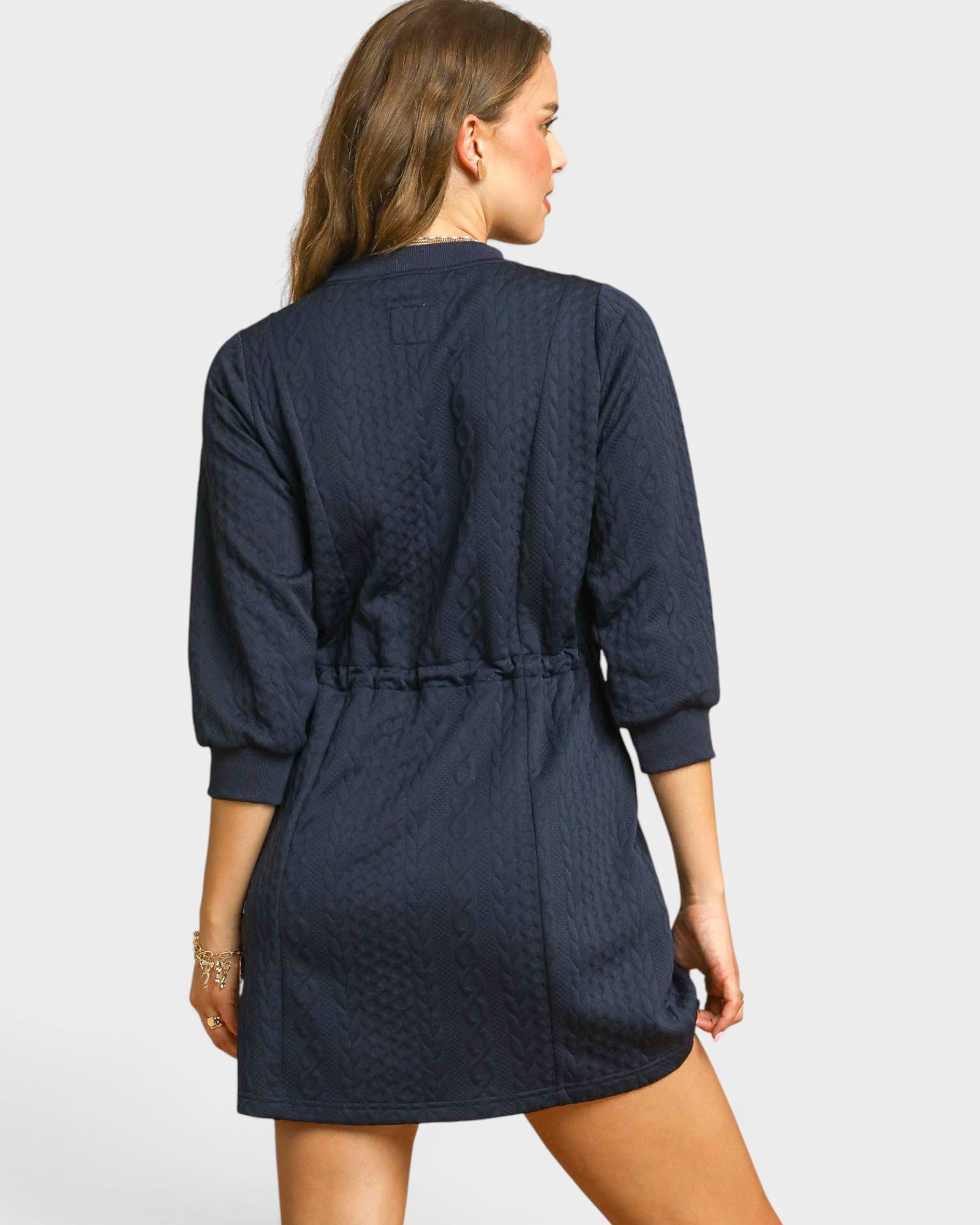 Navy blue dress worn by a person on a light gray background