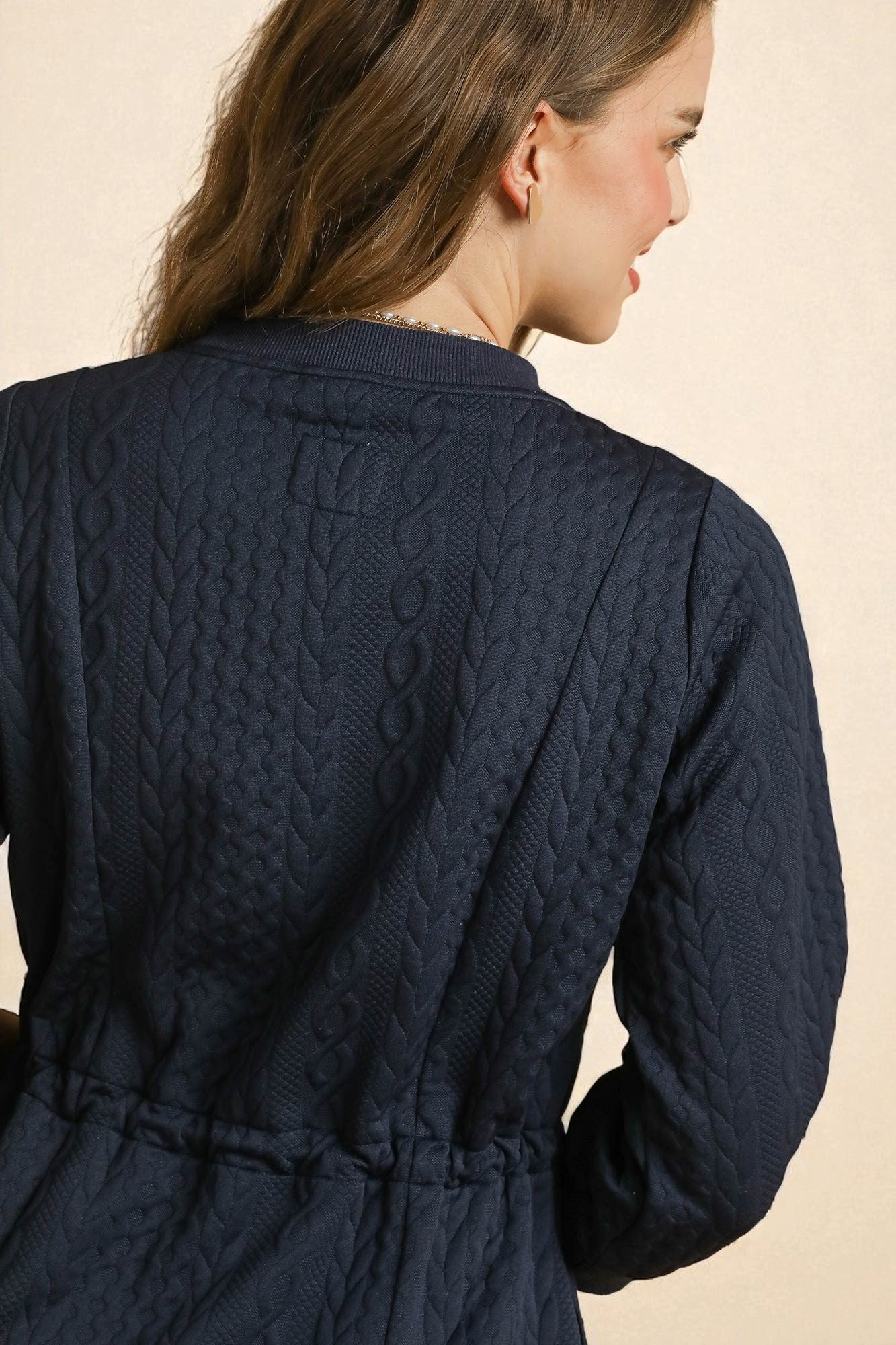 Navy quilted dress worn by a person on a beige background