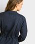 Woman wearing a navy quilted jacket on a plain background