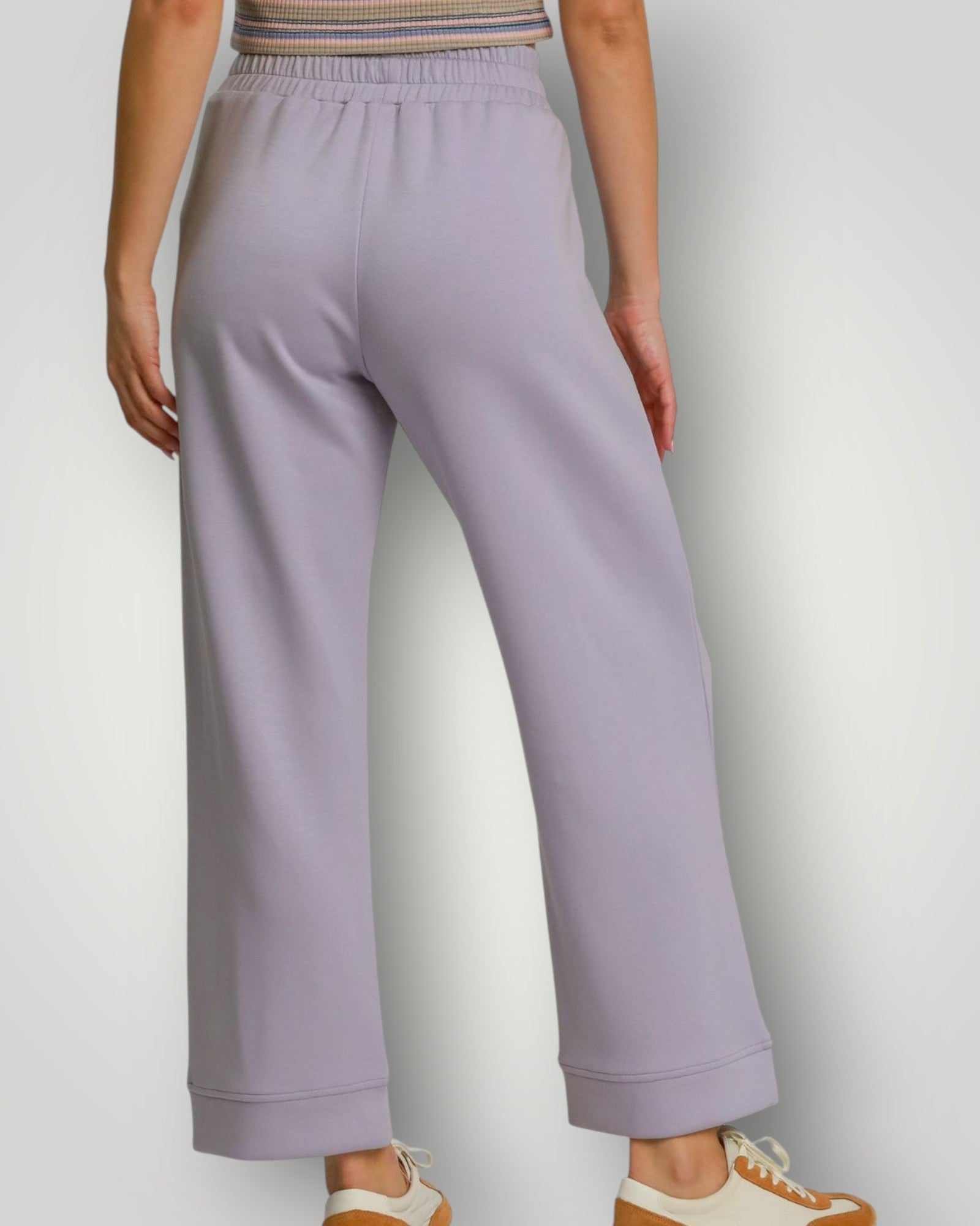 Person wearing light purple pants on a plain background