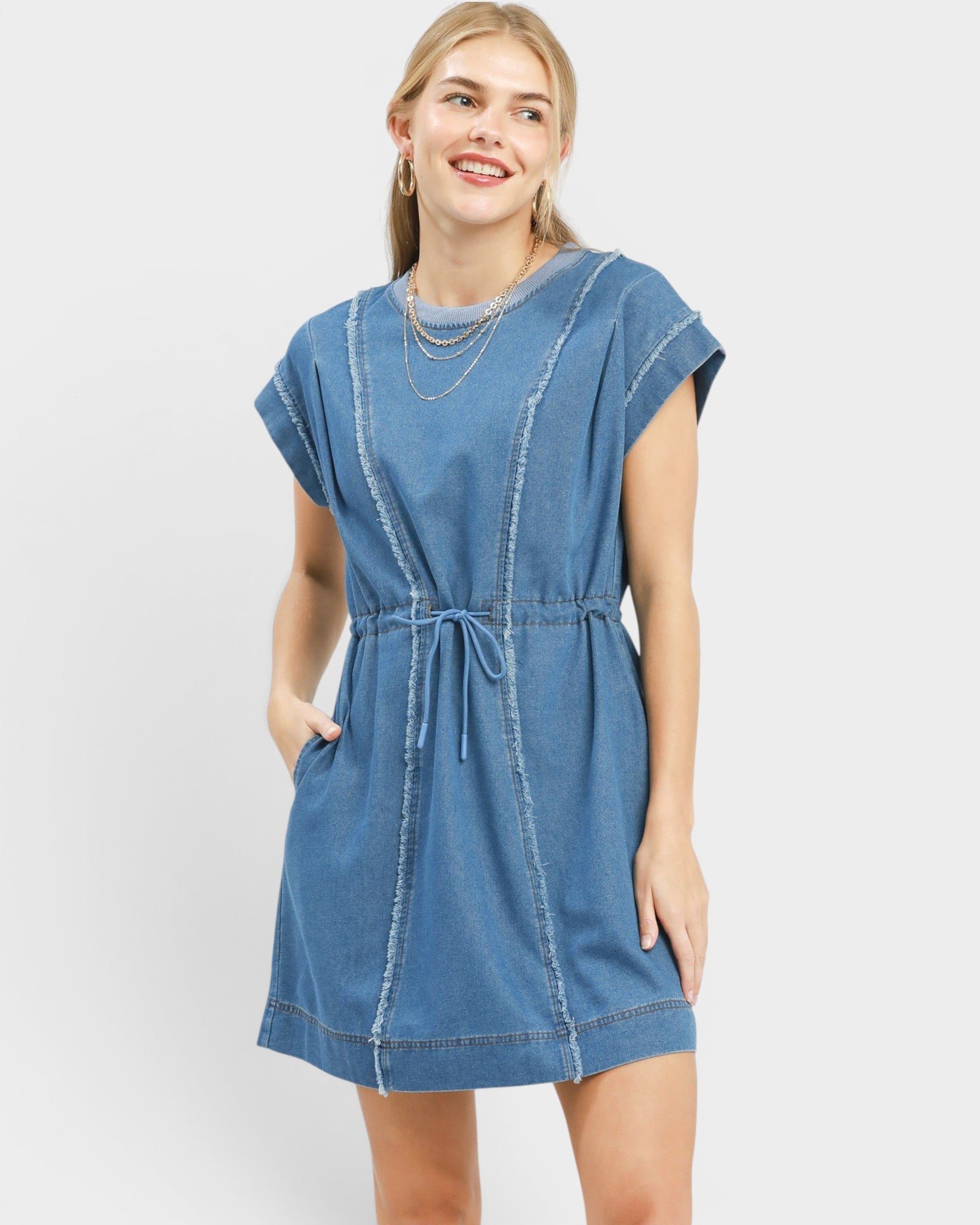 Woman wearing a blue denim dress on a white background