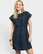 Woman wearing a dark blue denim dress on a white background