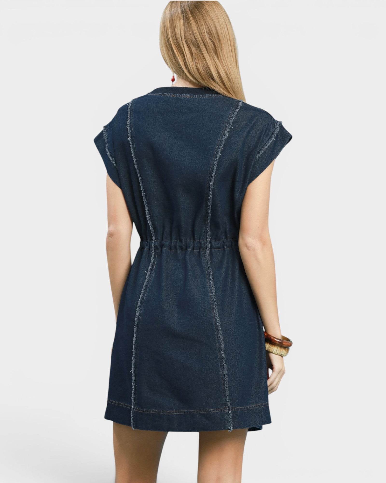 Woman wearing a navy denim dress on a white background
