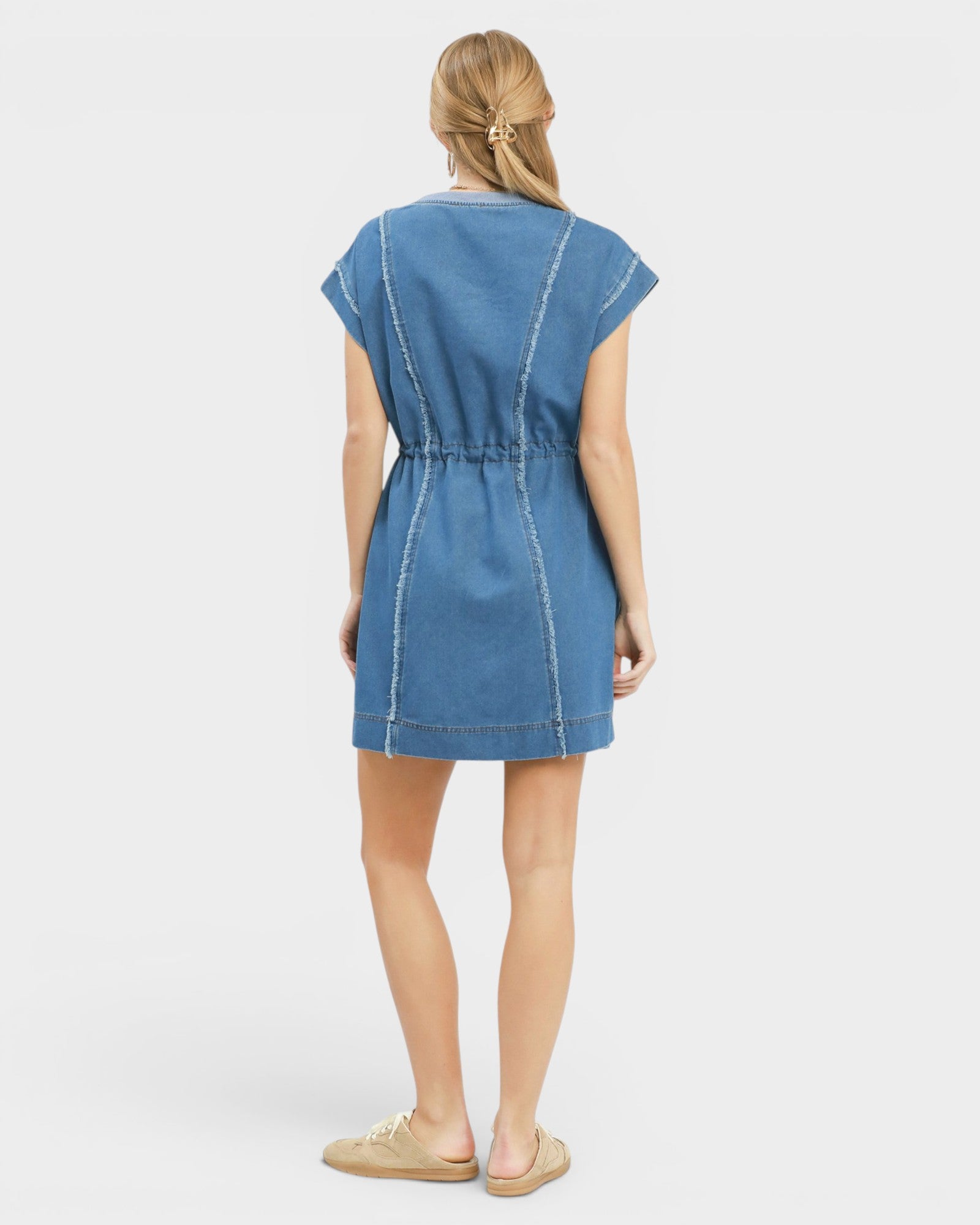 Woman wearing a blue denim dress on a white background