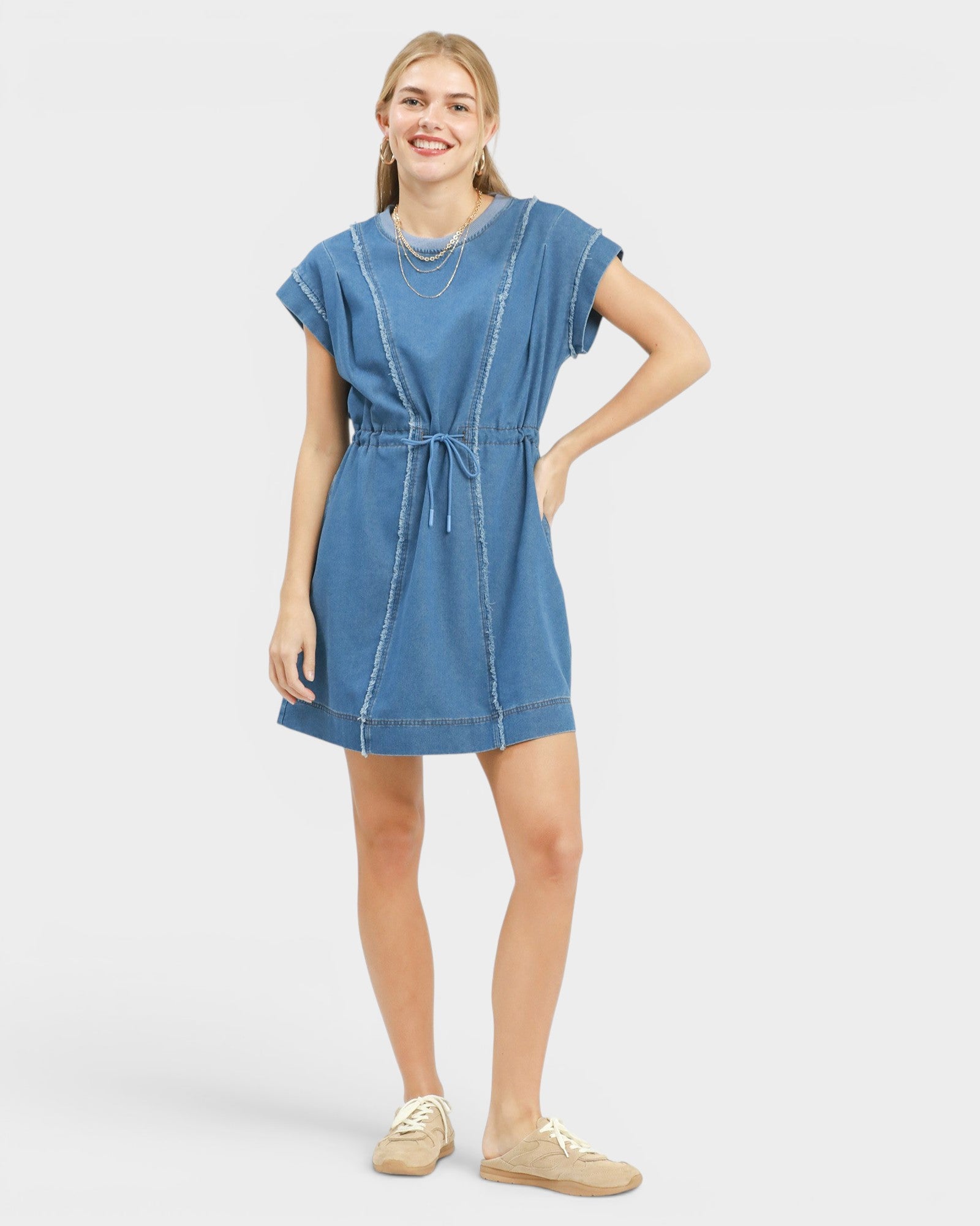 Woman wearing a blue denim dress on a white background