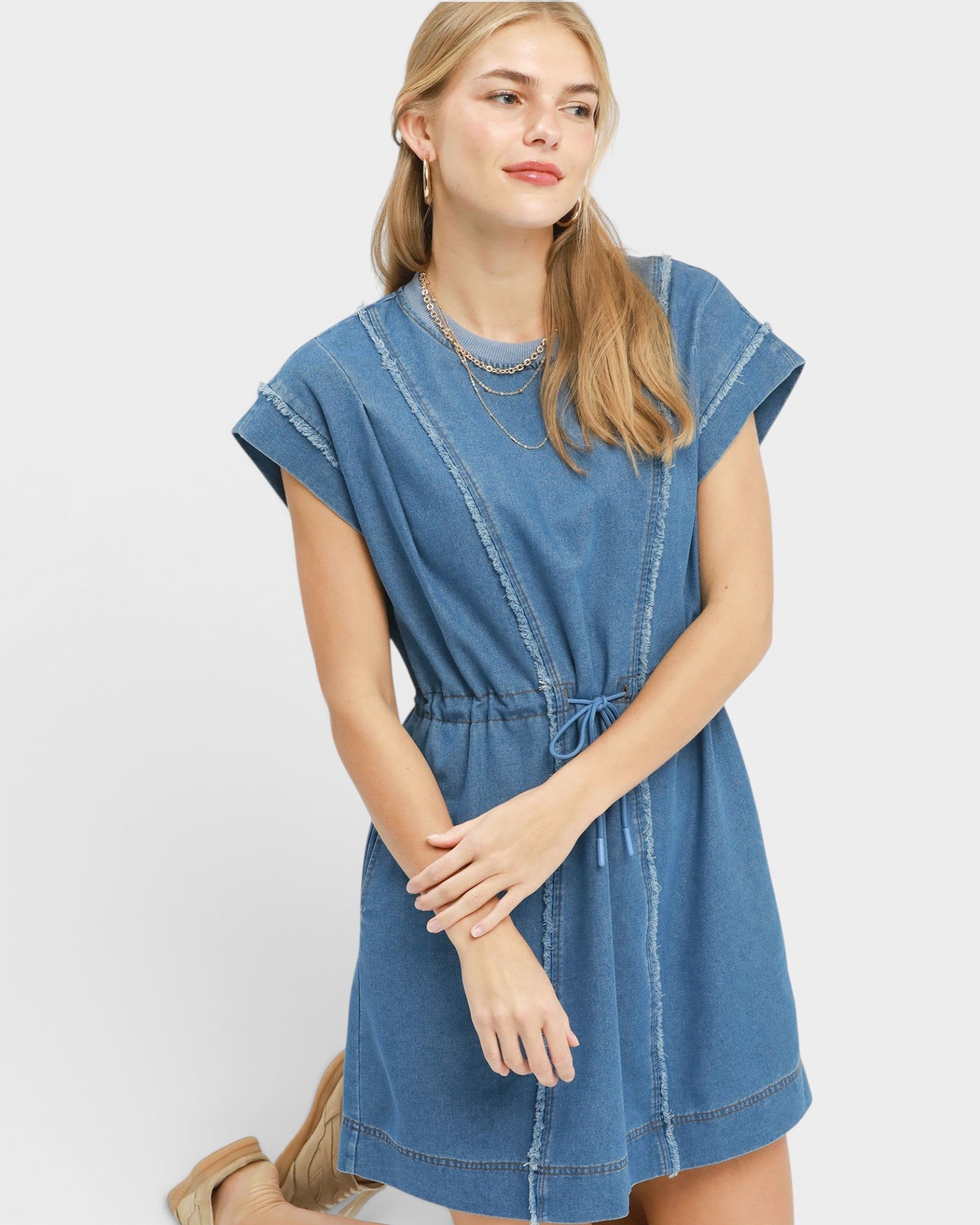 Woman wearing a blue denim dress on a white background