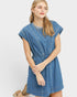 Woman wearing a blue denim dress on a white background