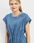Woman wearing a blue denim dress with a plain background