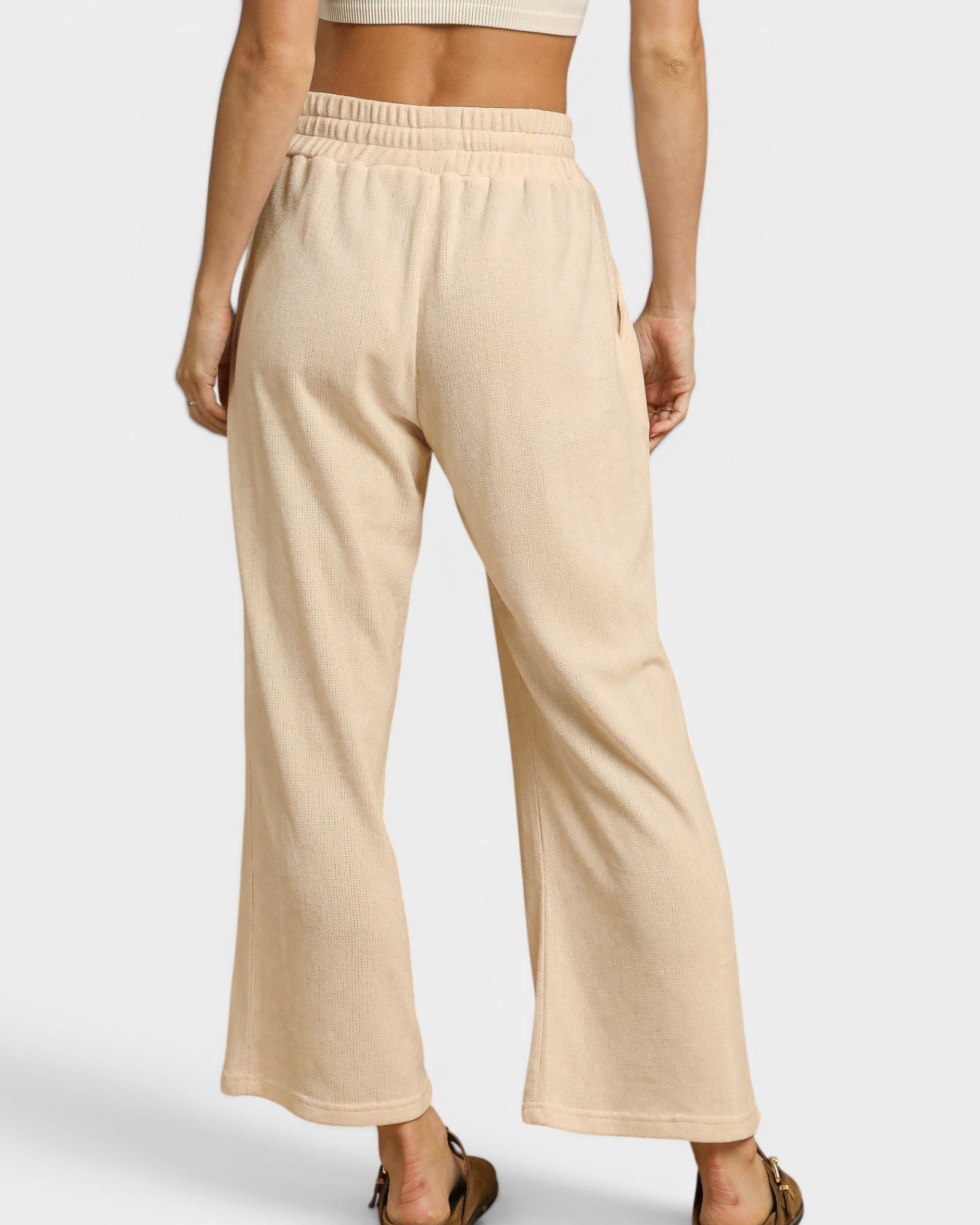 Beige wide-leg pants worn by a person on a plain background