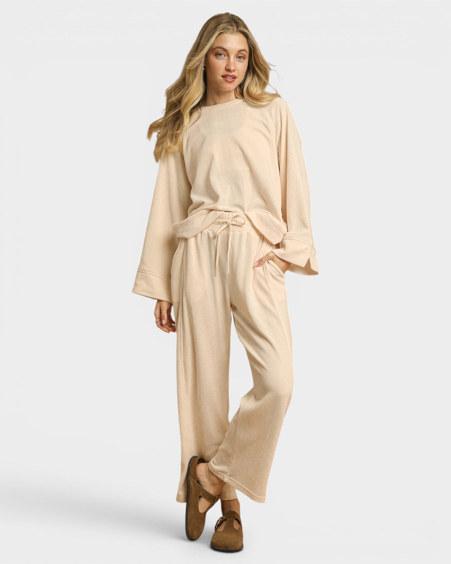 Woman wearing a beige outfit on a white background