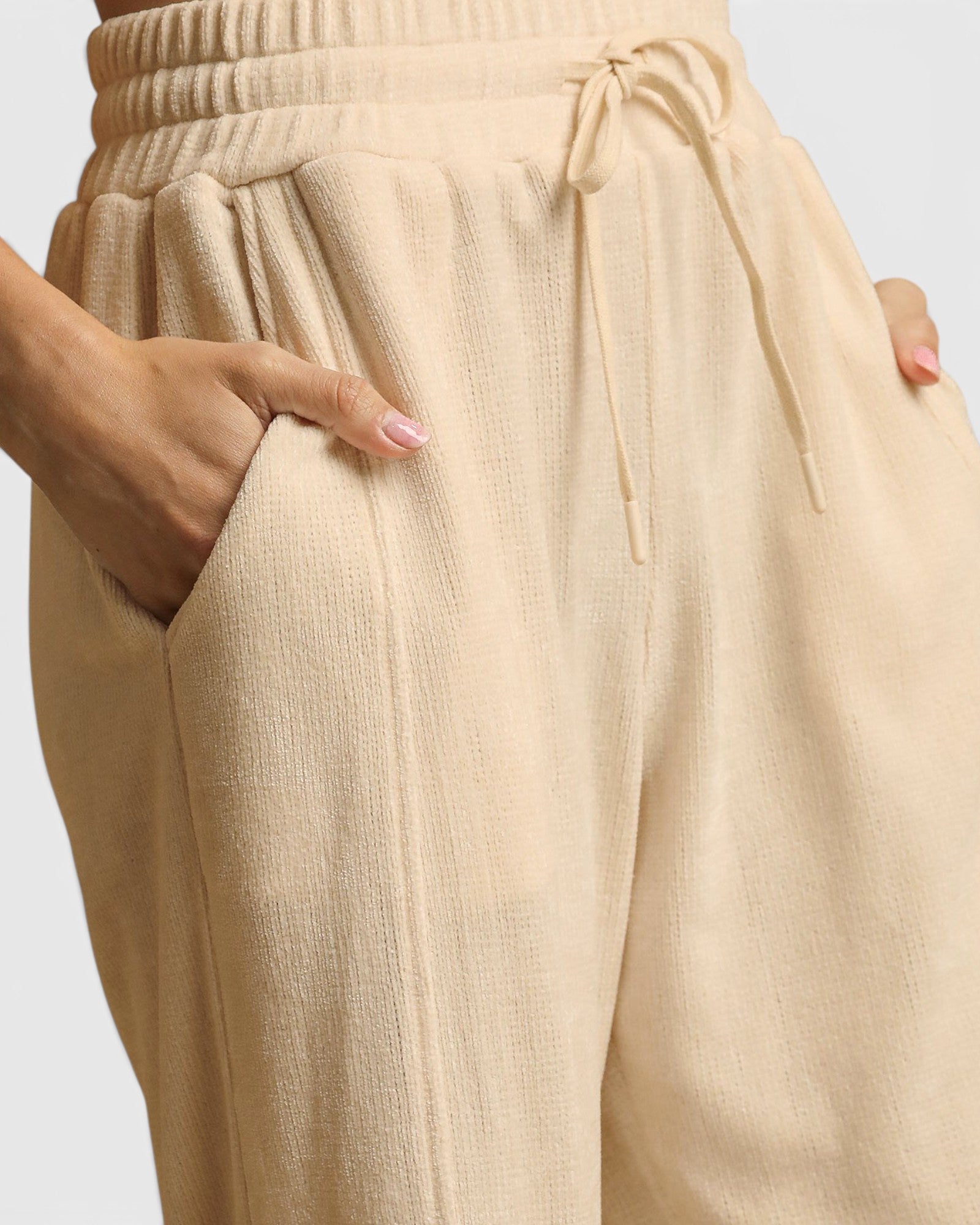 Beige pants with a drawstring waist on a light gray background